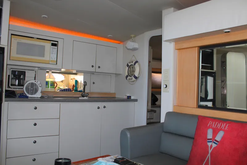 Slide: The Image of Interior of a 1996 Trojan 440 Express yacht with modern kitchen and cozy seating area. - 34