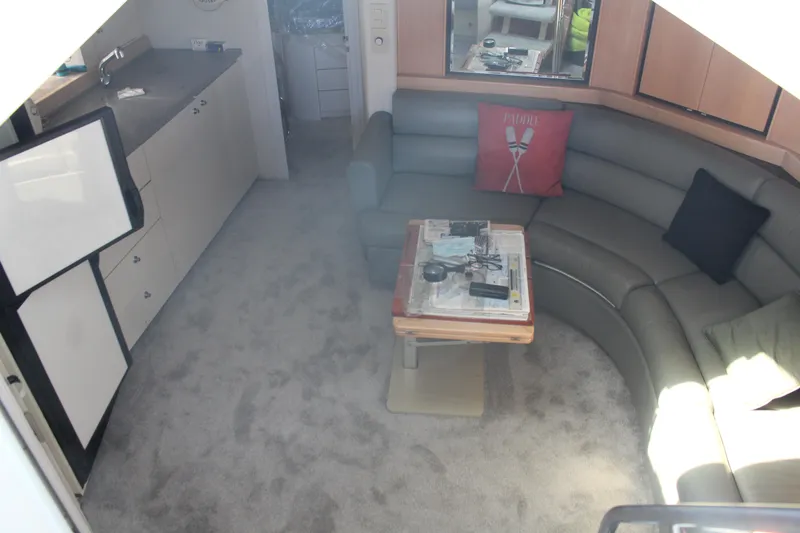 Slide: The Image of Interior of 1996 Trojan 440 Express yacht with curved seating and kitchenette. - 36