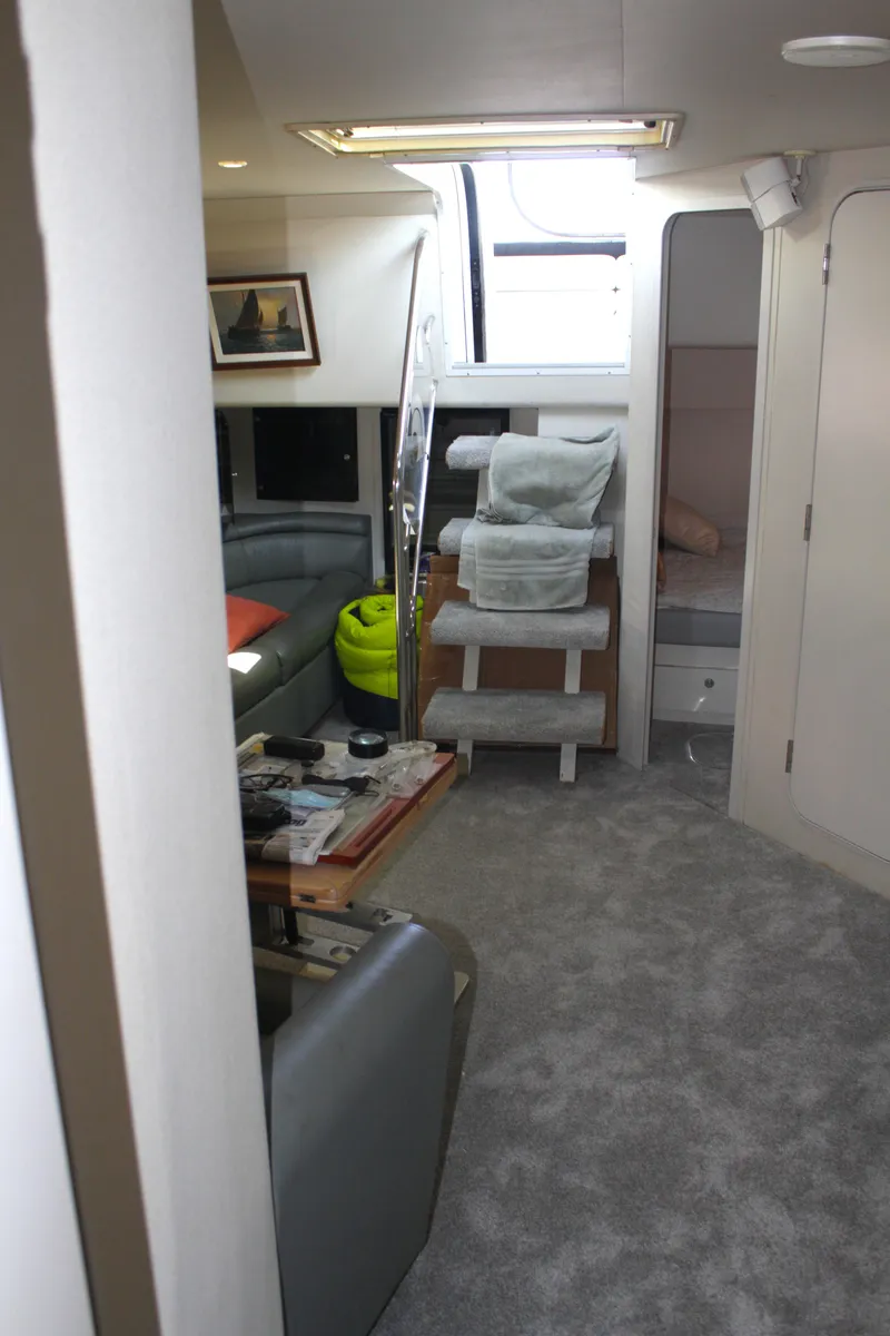 Slide: The Image of Interior of 1996 Trojan 440 Express yacht with modern furnishings and carpeted flooring. - 37