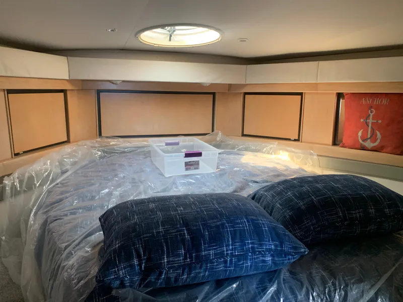 Slide: The Image of Cabin interior of 1996 Trojan 440 Express yacht with bed, pillows, and storage compartments. - 43