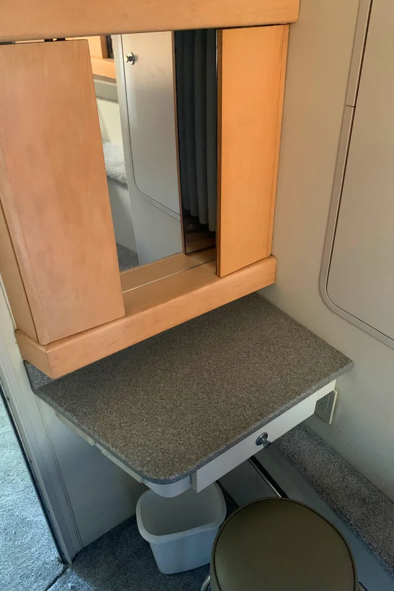 Slide: The Image of 1996 Trojan 440 Express interior with vanity mirror and stool. - 46