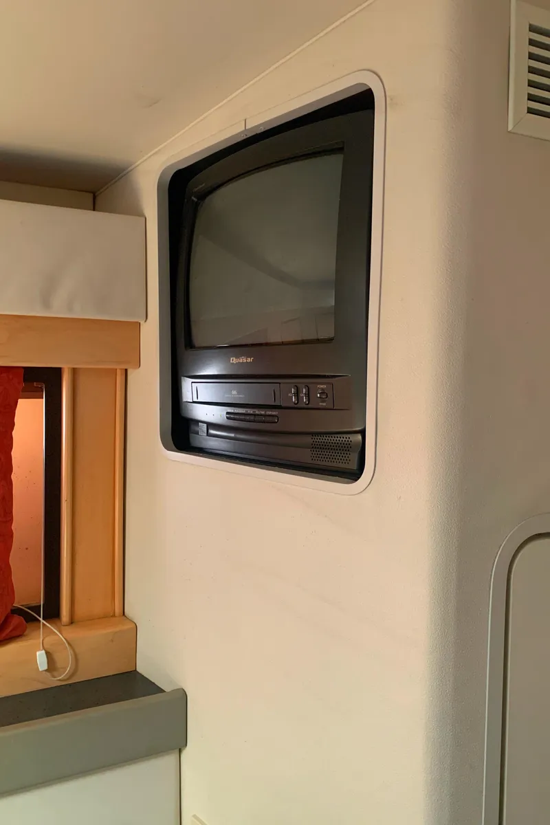 Slide: The Image of Built-in TV in a 1996 Trojan 440 Express boat interior. - 47
