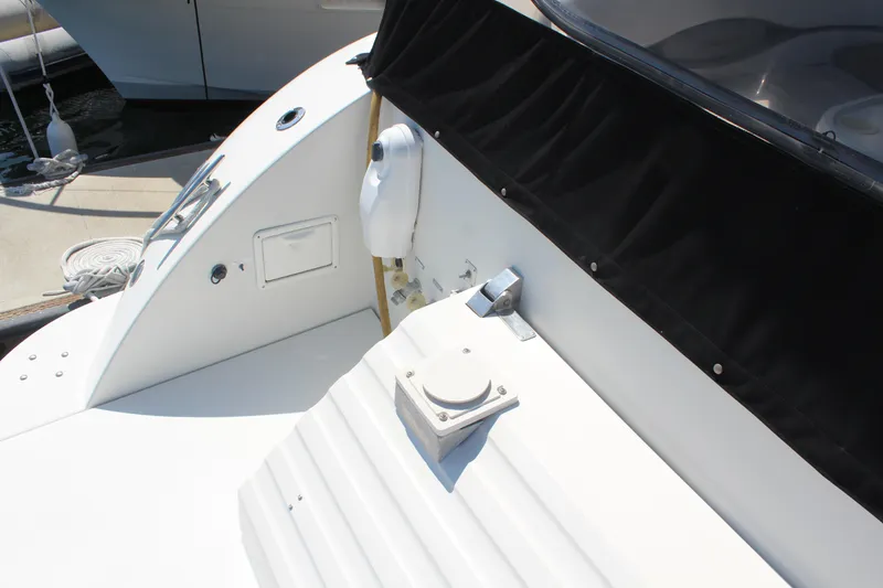 Slide: The Image of 1996 Trojan 440 Express yacht deck with black canopy and dockside view. - 5