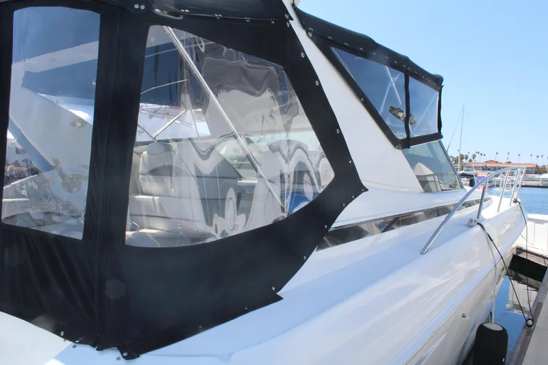 Slide: The Image of 1996 Trojan 440 Express yacht with black canvas enclosure at a marina. - 6