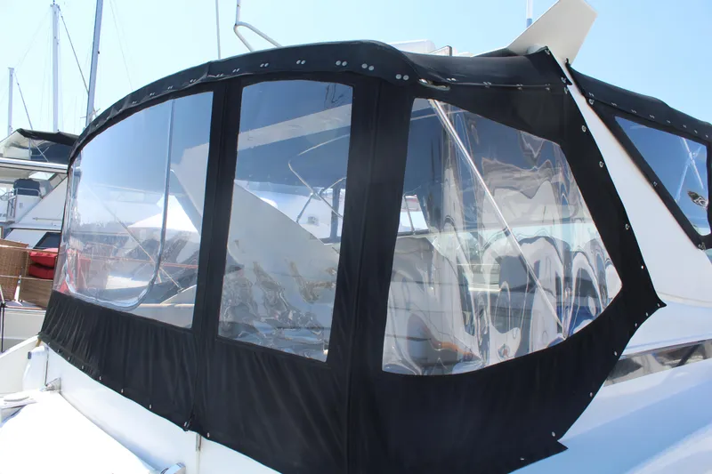 Slide: The Image of 1996 Trojan 440 Express boat with black canvas enclosure in marina. - 9