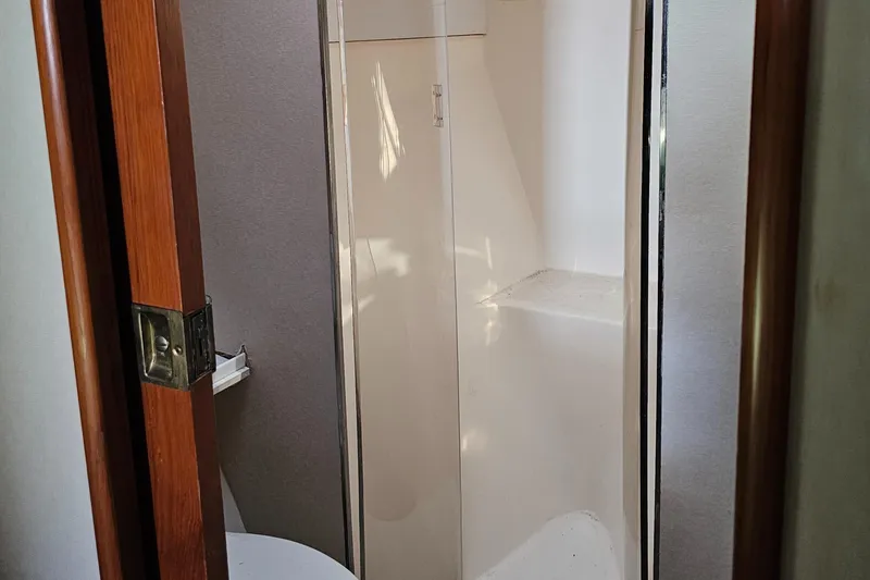 Slide: The Image of Interior of 1999 Ocean Yachts 48 Super Sport with beige seating and wooden cabinetry. - 16