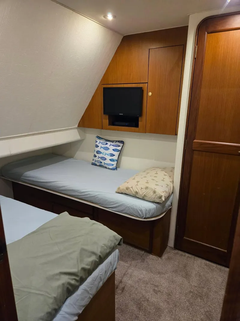 Slide: The Image of Cozy bedroom in 1999 Ocean Yachts 48 Super Sport with patterned bedding and wooden cabinetry. - 26