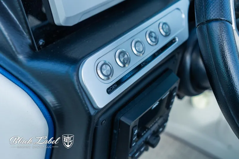 Slide: The Image of Control panel of 2024 Crownline 260 XSS boat with buttons and steering wheel. - 16