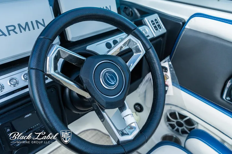 Slide: The Image of 2024 Crownline 260 XSS boat interior with steering wheel and Garmin displays. - 18