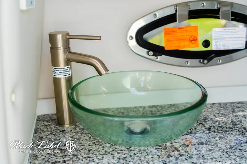 Slide: The Image of 2024 Crownline 260 XSS boat interior with glass sink and modern faucet. - 22