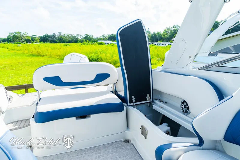 Slide: The Image of 2024 Crownline 260 XSS boat interior with blue and white seating and storage compartment. - 28
