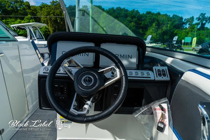 Slide: The Image of 2024 Crownline 260 XSS boat dashboard with steering wheel and Garmin displays. - 32