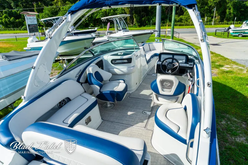 Slide: The Image of 2024 Crownline 260 XSS boat interior with blue and white seating, steering wheel, and open deck. - 34