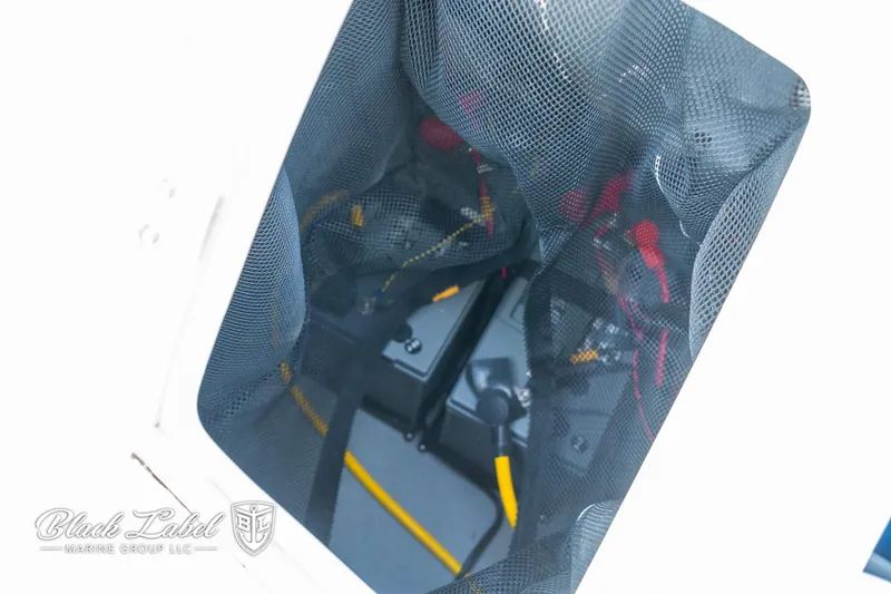 Slide: The Image of 2024 Crownline 260 XSS boat storage compartment with netting and visible equipment. - 36