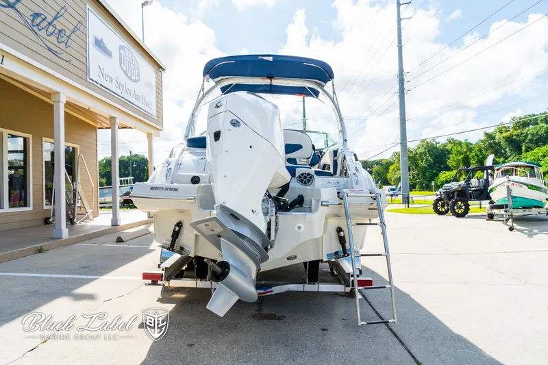 Slide: The Image of 2024 Crownline 260 XSS boat displayed outdoors with outboard motor and ladder. - 4