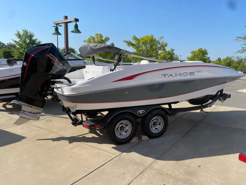 The Image of 2024 Tahoe 1950 boat on a trailer in a sunny outdoor setting. - 0