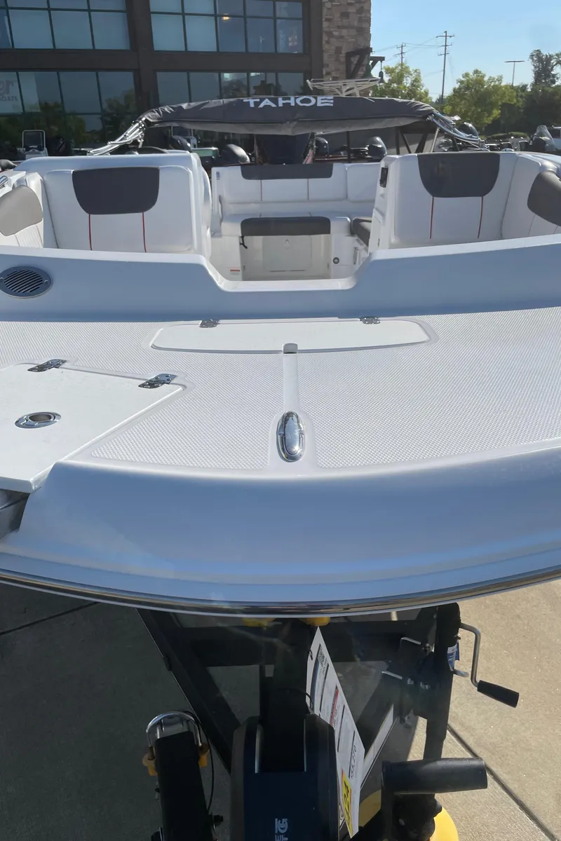 Slide: The Image of 2024 Tahoe 1950 boat, white exterior, docked outdoors. - 2