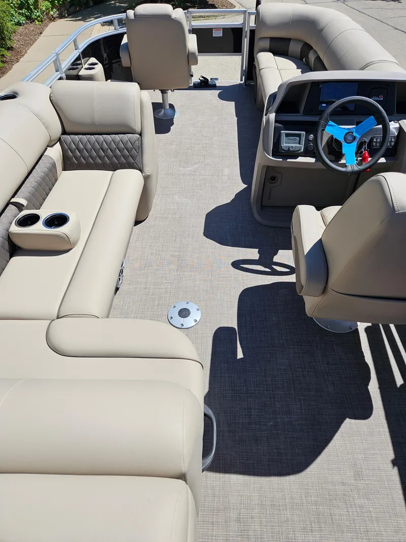 Slide: The Image of 2024 Sun Tracker SportFish 20 DLX pontoon boat interior with beige seating and modern dashboard. - 2