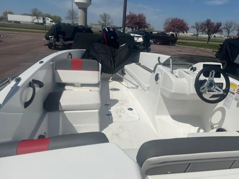 Slide: The Image of 2024 Tahoe T18 boat interior with seating and steering wheel, parked outdoors. - 3