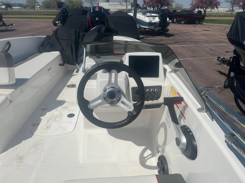 Slide: The Image of 2024 Tahoe T18 boat cockpit with steering wheel and control panel in a parking lot. - 4