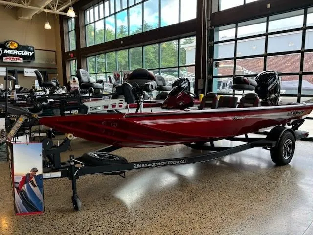 Slide: The Image of 2024 Ranger RT178 boat in showroom, red color, on trailer, with Mercury engine. - 0