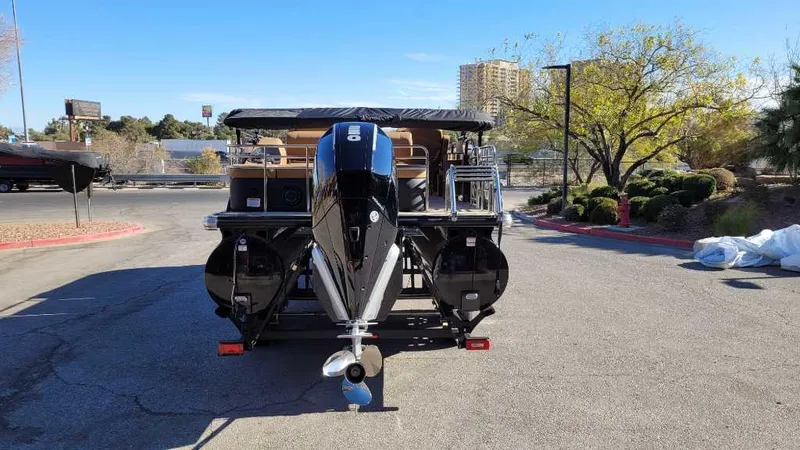 Slide: The Image of 2024 Regency 230 LE3 Sport pontoon boat with outboard motor in a parking lot. - 5