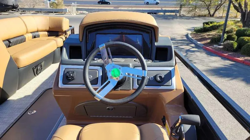 Slide: The Image of 2024 Regency 230 LE3 Sport boat interior with steering wheel and dashboard. - 7