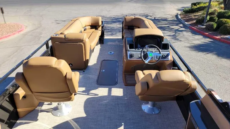 Slide: The Image of 2024 Regency 230 LE3 Sport pontoon boat with luxurious tan seating and modern helm. - 8