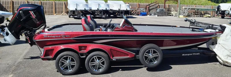 Slide: The Image of 2024 Ranger Z521R Ranger Cup Equipped boat, red and black, on a trailer in a parking lot. - 0