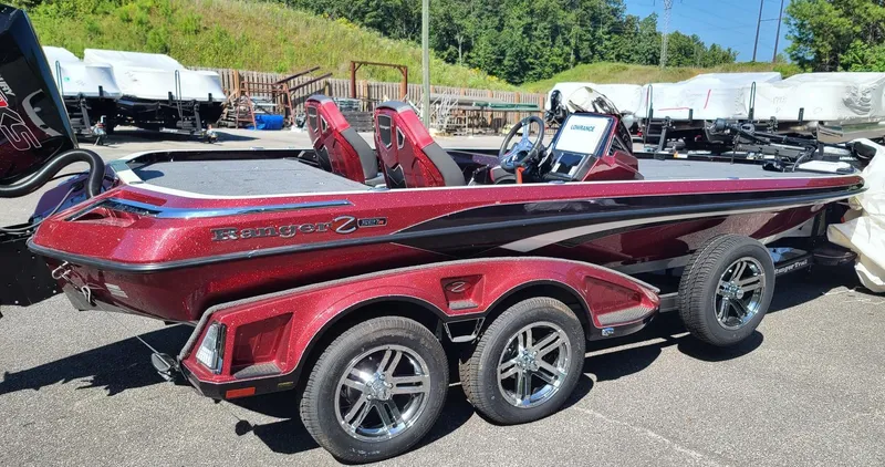 Slide: The Image of 2024 Ranger Z521R Ranger Cup Equipped boat, red and black, parked outdoors. - 2