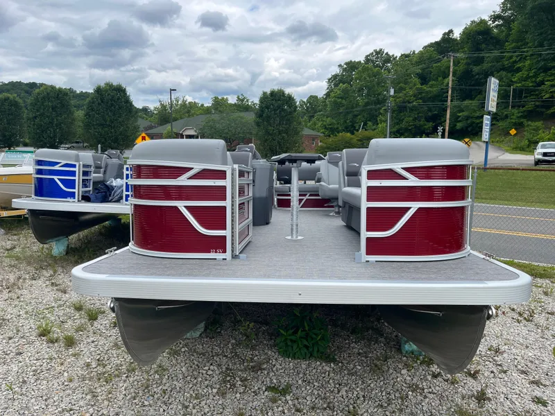 Slide: The Image of 2024 Bennington 20 SVSR pontoon boat on gravel lot with trees and road in background. - 3