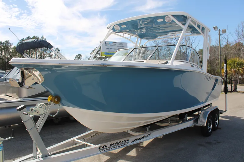 Slide: The Image of 2024 Sea Pro 240 boat on a trailer, blue hull, white trim, outdoor display. - 0