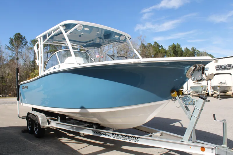Slide: The Image of 2024 Sea Pro 240 boat on a trailer, blue hull, parked outdoors. - 1