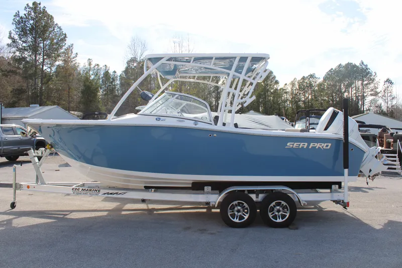 Slide: The Image of 2024 Sea Pro 240 boat on a trailer, side view, blue and white color. - 2