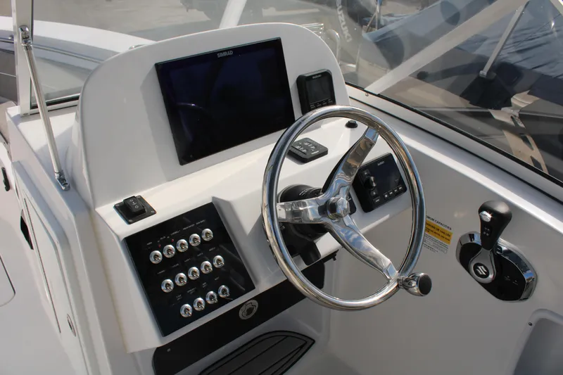Slide: The Image of 2024 Sea Pro 240 boat helm with steering wheel and control panel. - 20