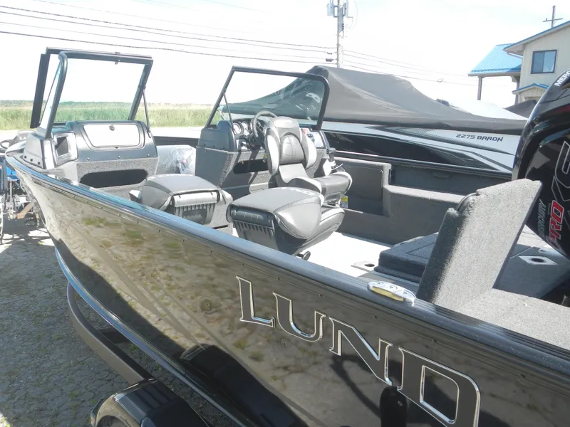 Slide: The Image of 2024 Lund 1875 Impact XS Sport boat with sleek black exterior and spacious interior. - 3