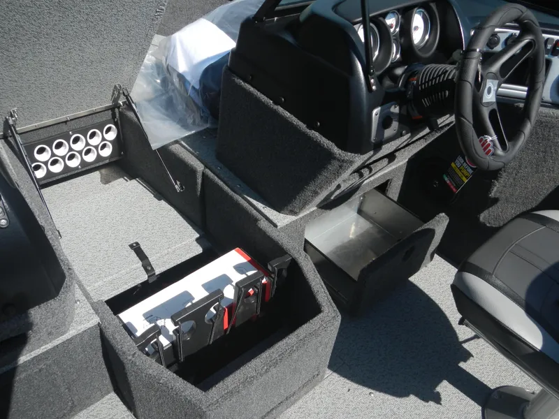 Slide: The Image of 2024 Lund 1875 Impact XS Sport boat interior storage compartments and dashboard. - 9