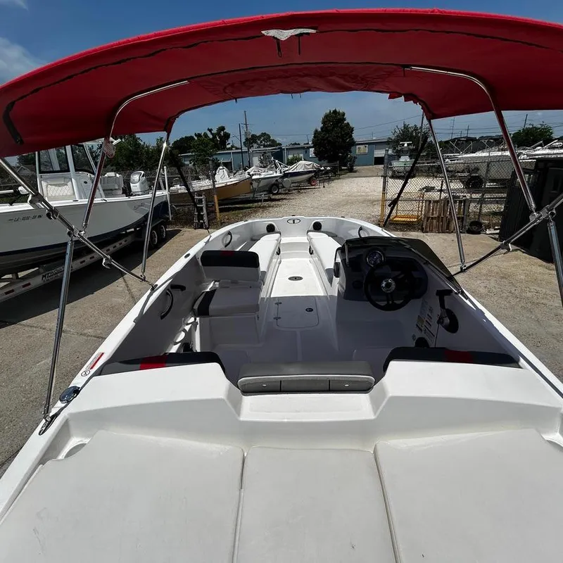 Slide: The Image of 2022 Tahoe T18 boat with red canopy, docked at a marina. - 15