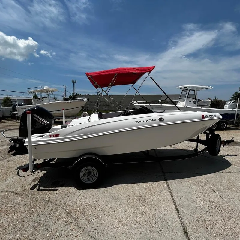 Slide: The Image of 2022 Tahoe T18 boat with red canopy on trailer under blue sky. - 2