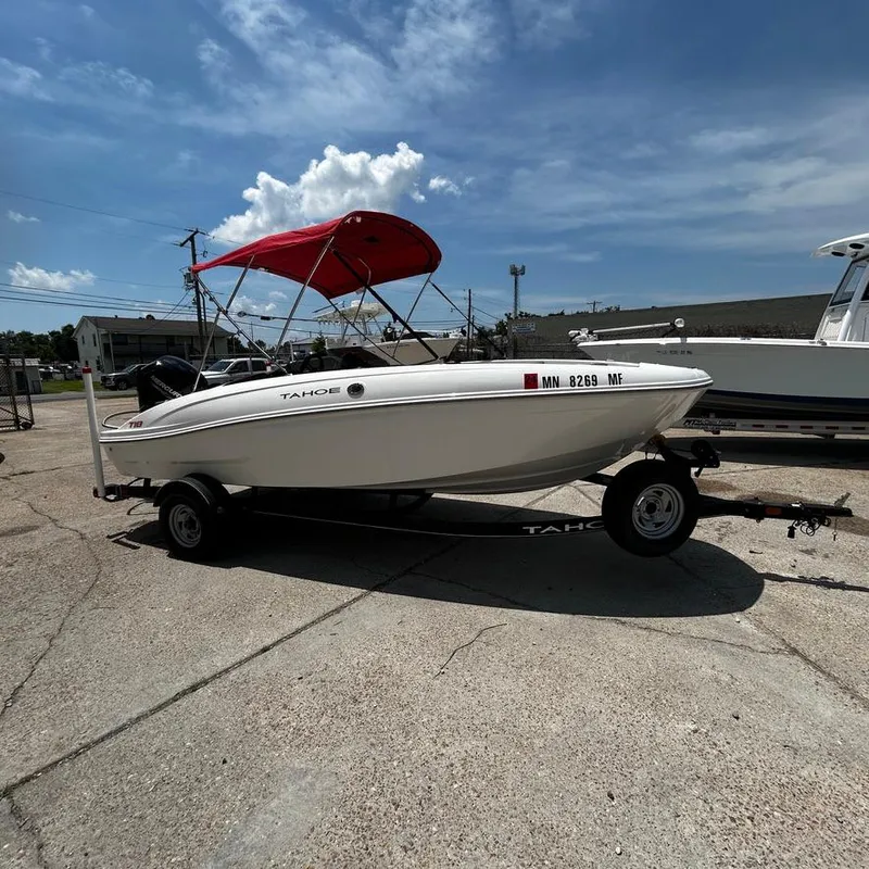Slide: The Image of 2022 Tahoe T18 boat with red canopy on trailer under blue sky. - 3