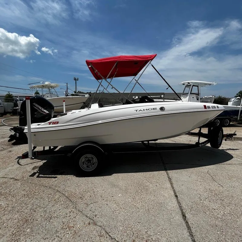 Slide: The Image of 2022 Tahoe T18 boat with red canopy on trailer under blue sky. - 4