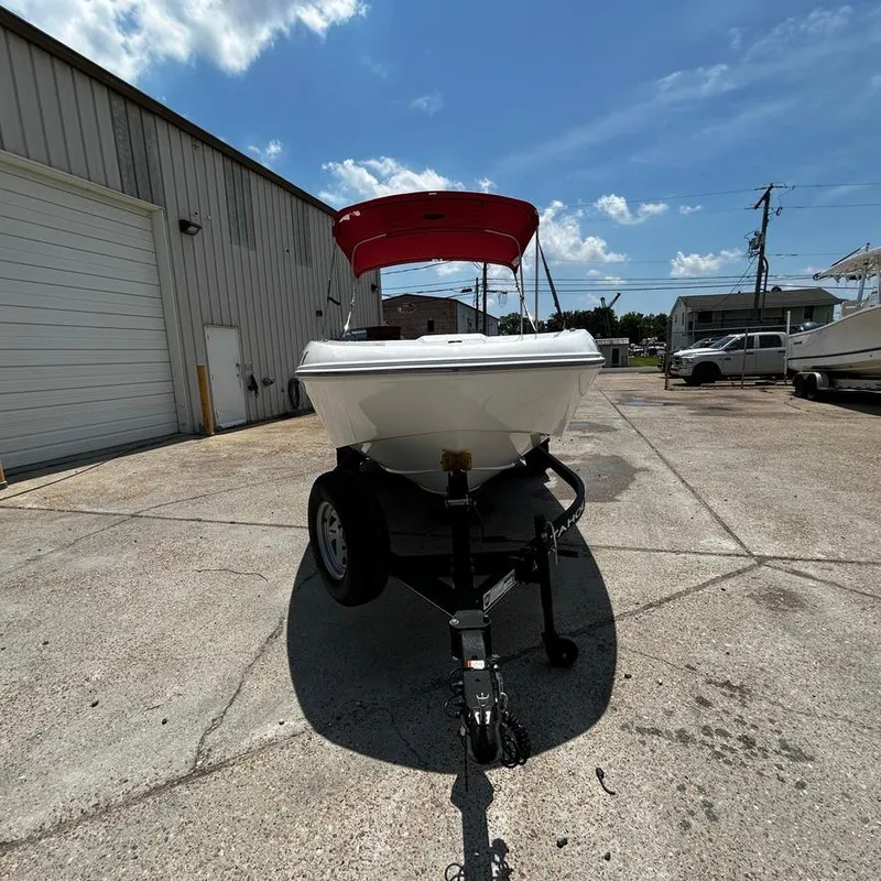 Slide: The Image of 2022 Tahoe T18 boat on trailer with red canopy in industrial lot. - 8
