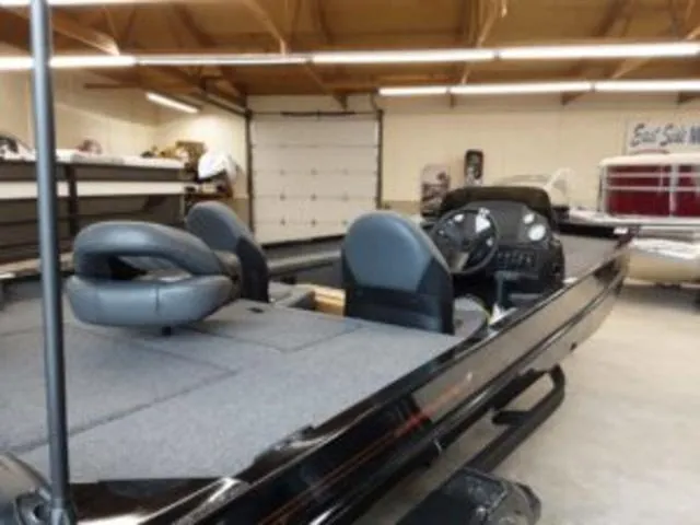 Slide: The Image of 2023 Lowe RX1860 boat in a showroom, featuring dual seats and a steering console. - 8