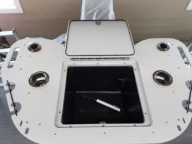 Slide: The Image of 2023 Lowe SF194 boat storage compartment with open lid and cup holders. - 10