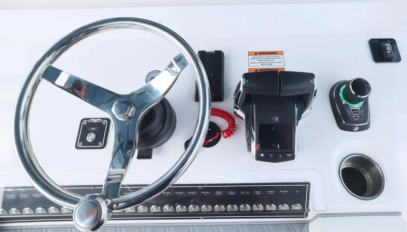 Slide: The Image of Steering console of 2024 Invincible 46 Catamaran with modern controls and chrome wheel. - 17