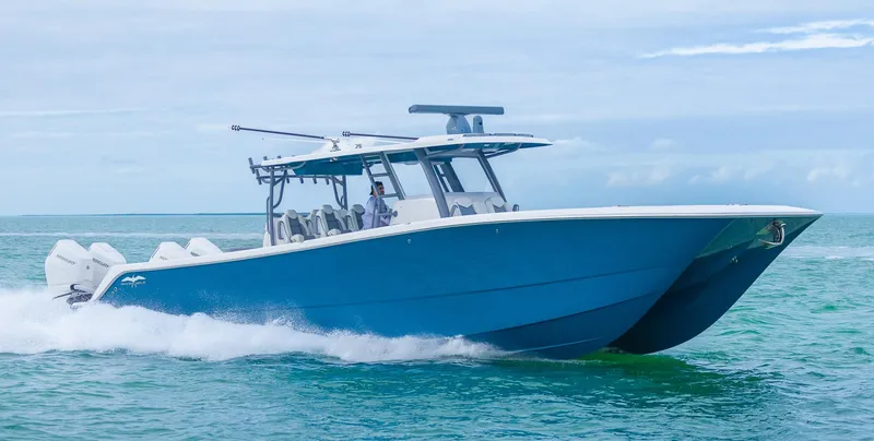 Slide: The Image of 2024 Invincible 46 Catamaran cruising on open water, showcasing sleek design and powerful engines. - 2