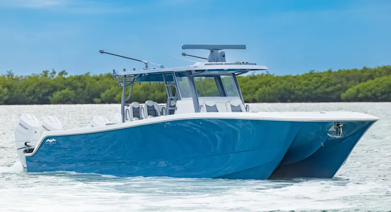 Slide: The Image of 2024 Invincible 46 Catamaran cruising on water, featuring sleek blue design and modern amenities. - 38