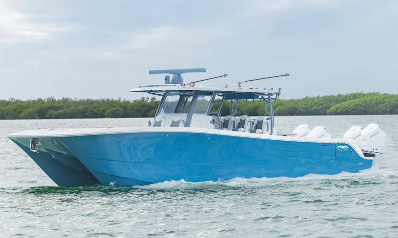 Slide: The Image of 2024 Invincible 46 Catamaran cruising on water, showcasing sleek blue design and powerful engines. - 4