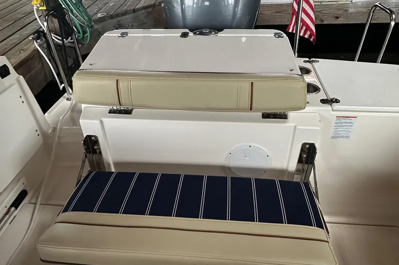 Slide: The Image of Ranger Tugs R-27 2021 boat seating area with striped cushions and American flag. - 4