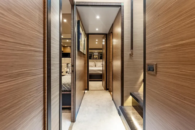 Slide: The Image of Luxurious interior hallway of 2016 Azimut Magellano 76 yacht with modern wood paneling. - 27